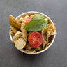 Pasta dish with tomatoes and basil in a white bowl on a dark surface